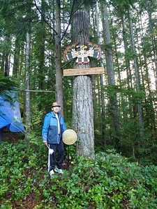 shíshálh Elder Willard Joe completes his drum song while other Elders and community members look on